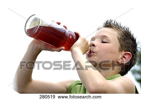 Close-up of teenage boy drinking juice View Large Photo Image Stock Photo - Close-up of teenage boy drinking juice . Fotosearch