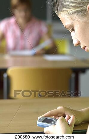 Close-up of teenage girl using mobile phone in classroom View Large Photo Image Stock Image - Close-up of teenage girl using mobile phone in classroom . Fotosearch
