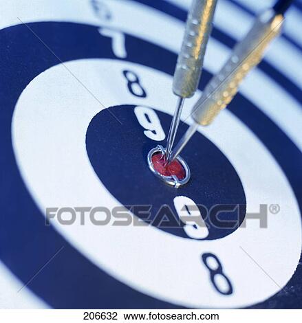 Stock Image - Close-up of two darts on bull's eye on dart board . Fotosearch
