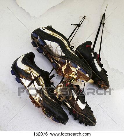 Stock Photograph - Close-up of two pair of shoes hanging in wall . Fotosearch