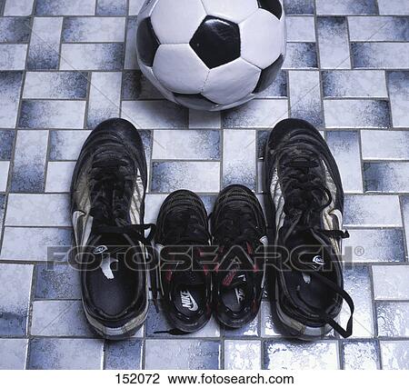 Stock Image - Close-up of two pairs of soccer shoes and ball . Fotosearch