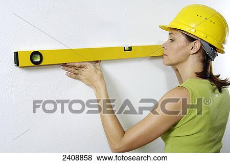 Close-up of woman using spirit level on wall View Large Photo Image Stock Photo - Close-up of woman using spirit level on wall . Fotosearch