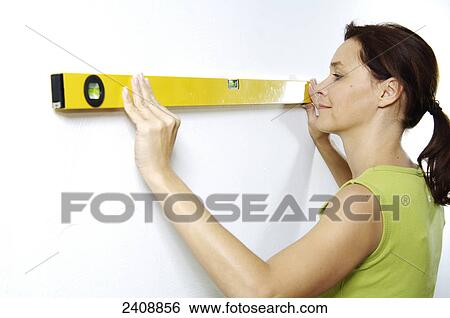 Close-up of woman using spirit level on wall View Large Photo Image Stock Photograph - Close-up of woman using spirit level on wall . Fotosearch