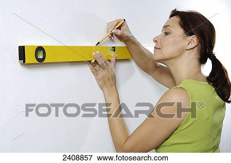 Close-up of woman using spirit level to mark wall View Large Photo Image Stock Photo - Close-up of woman using spirit level to mark wall . Fotosearch