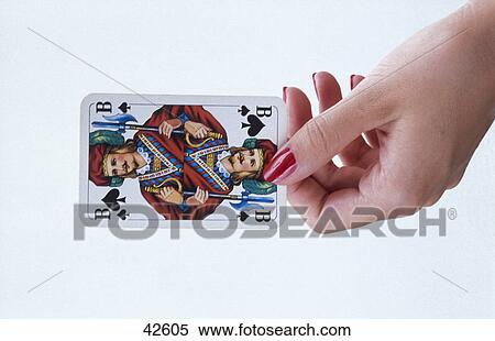 Stock Photography - Close-up of woman's hand holding jack of spades card . Fotosearch