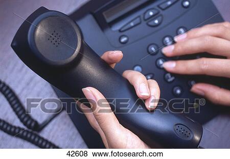 Stock Photo - Close-up of woman's hands dialing landline phone . Fotosearch