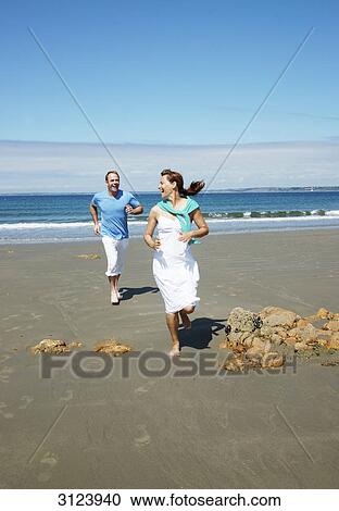 Couple running on the beach, front view View Large Photo Image Stock Image - Couple running on the beach, front view . Fotosearch