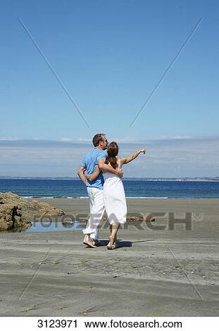 Couple walking along the beach, rear view View Large Photo Image Stock Image - Couple walking along the beach, rear view . Fotosearch