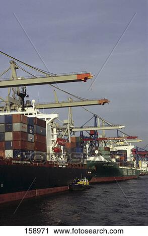 Stock Image - Cranes and container ship at port, Elbe River, Hamburg, Germany . Fotosearch