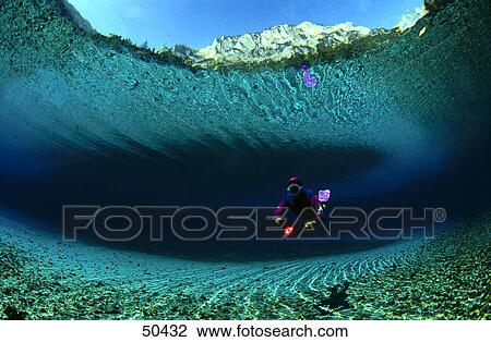 Stock Image - Diver underwater with mountain in background, Alpine Lake, Austria . Fotosearch
