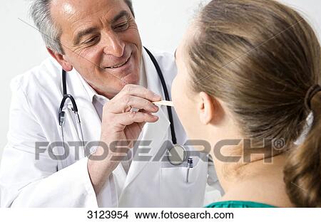 Picture - Doctor examining a female patient . Fotosearch