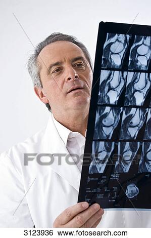 Doctor looking at x-ray image View Large Photo Image Stock Photograph - Doctor looking at x-ray image . Fotosearch