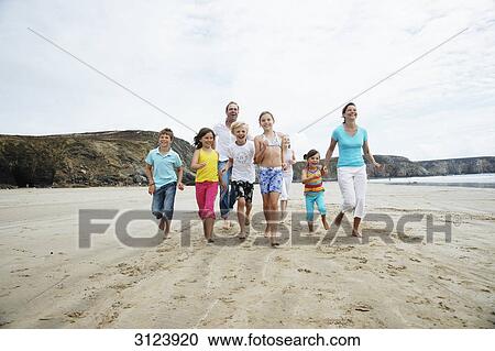 Family running on the beach, front view View Large Photo Image Stock Image - Family running on the beach, front view . Fotosearch