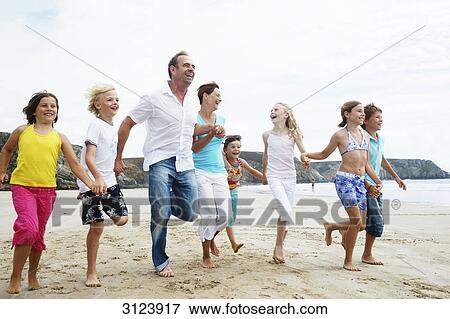 Family running on the beach View Large Photo Image Stock Photo - Family running on the beach . Fotosearch