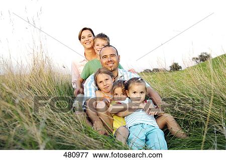Family sitting in row on grass View Large Photo Image Stock Photo - Family sitting in row on grass . Fotosearch