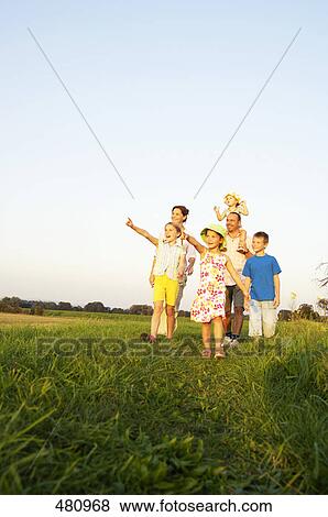 Family walking in field View Large Photo Image Stock Photo - Family walking in field . Fotosearch