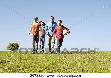 Stock Photograph - Family walking over meadow . Fotosearch