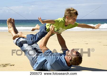 Father and son having fun at beach View Large Photo Image Stock Image - Father and son having fun at beach . Fotosearch