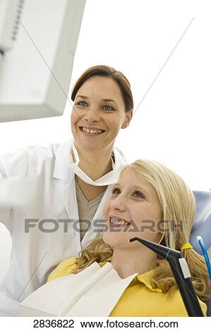 Female dentist and patient looking at monitor View Large Photo Image Stock Image - Female dentist and patient looking at monitor . Fotosearch