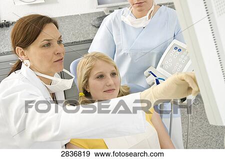 Female dentist and patient looking at monitor View Large Photo Image Stock Photo - Female dentist and patient looking at monitor . Fotosearch