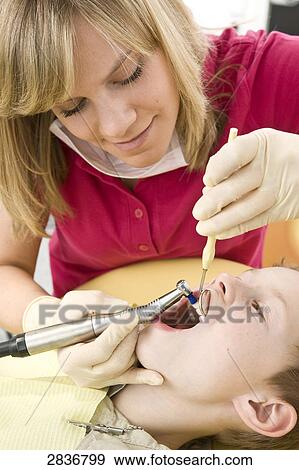 Stock Photo - Female dentist examining patient's teeth . Fotosearch