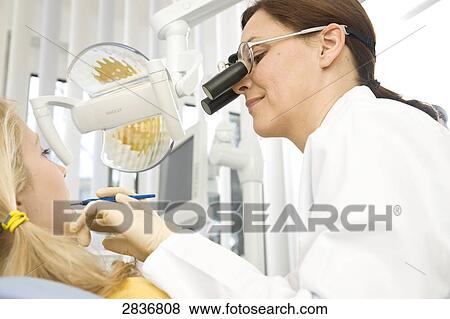 Female dentist examining patient's teeth View Large Photo Image Stock Photo - Female dentist examining patient's teeth . Fotosearch