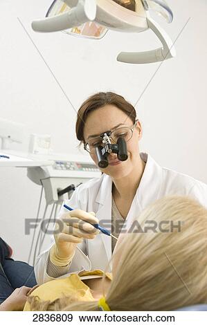 Female dentist examining patient's teeth View Large Photo Image Stock Photo - Female dentist examining patient's teeth . Fotosearch
