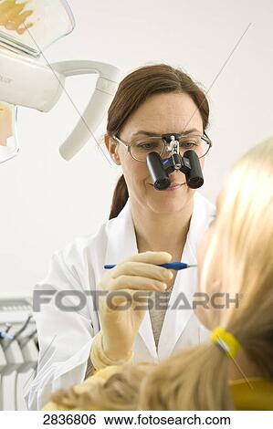 Female dentist examining patient's teeth View Large Photo Image Stock Photograph - Female dentist examining patient's teeth . Fotosearch