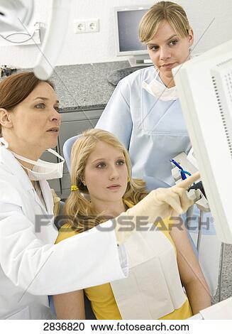 Female dentists and patient looking at monitor View Large Photo Image Stock Image - Female dentists and patient looking at monitor . Fotosearch