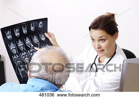 Female doctor showing an x-ray to a patient View Large Photo Image Stock Photograph - Female doctor showing an x-ray to a patient . Fotosearch