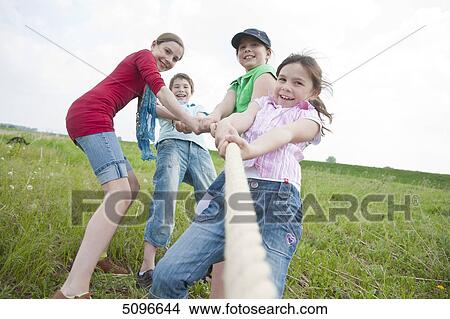 Four children playing tug-of-war View Large Photo Image Picture - Four children playing tug-of-war . Fotosearch