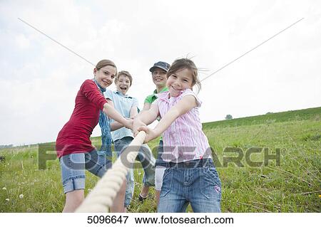 Stock Photo - Four children playing tug-of-war . Fotosearch