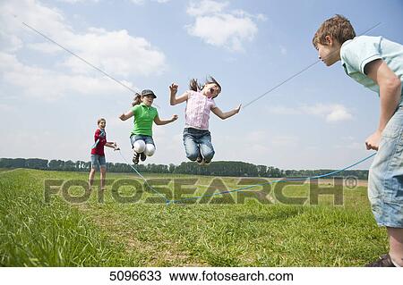 Four children skipping rope in meadow View Large Photo Image Stock Image - Four children skipping rope in meadow . Fotosearch