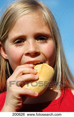 Stock Photograph - Girl eating biscuit . Fotosearch