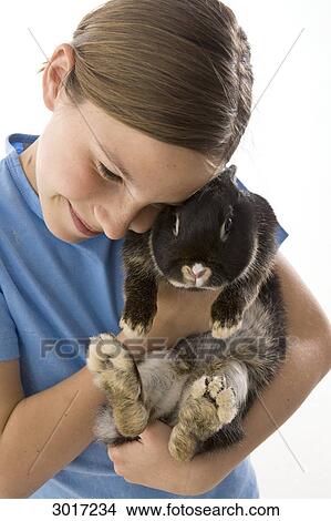 Girl holding a rabbit, Studio Shot, close-up View Large Photo Image Picture - Girl holding a rabbit, Studio Shot, close-up . Fotosearch