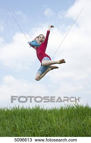 Stock Image - Girl jumping in meadow . Fotosearch