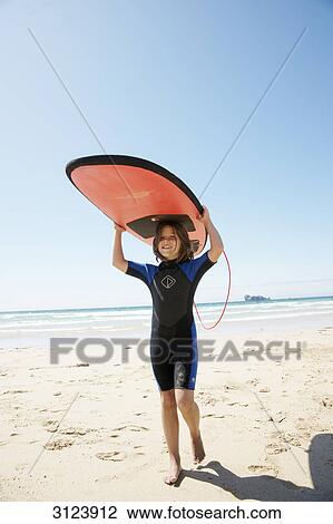 Girl on the beach holding surfboard above her head View Large Photo Image Stock Image - Girl on the beach holding surfboard above her head . Fotosearch