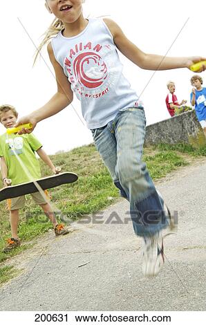Stock Image - Girl skipping on road . Fotosearch