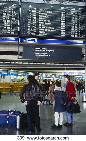 Stock Photo - Group of people in front of arrival departure board at airport, Frankfurt, Germany . Fotosearch
