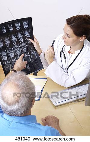 High angle view of female doctor showing an x-ray to a patient View Large Photo Image Stock Image - High angle view of female doctor showing an x-ray to a patient . Fotosearch