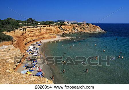 Picture - High angle view of tourists on beach, Sa Caleta Beach, Ibiza, Balearic Islands, Spain . Fotosearch