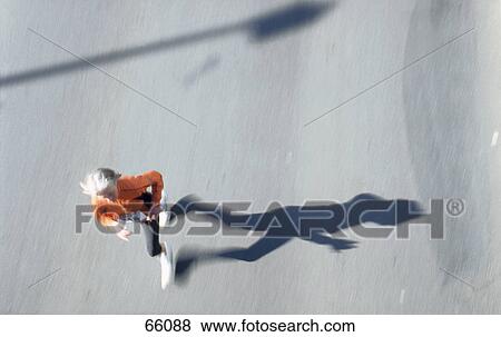 Stock Photo - High angle view of woman running in marathon . Fotosearch