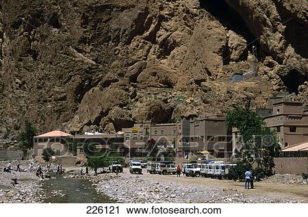 Stock Image - Jeeps parked in front of hotel on arid landscape, Dades Valley, Morocco . Fotosearch