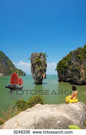 Stock Photograph - Junk and woman on rock, Phang-Nga, Thailand . Fotosearch