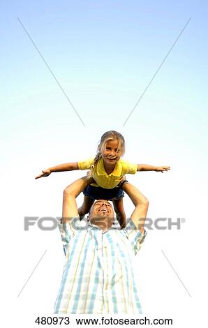 Low angle view of father playing with her daughter View Large Photo Image Stock Image - Low angle view of father playing with her daughter . Fotosearch