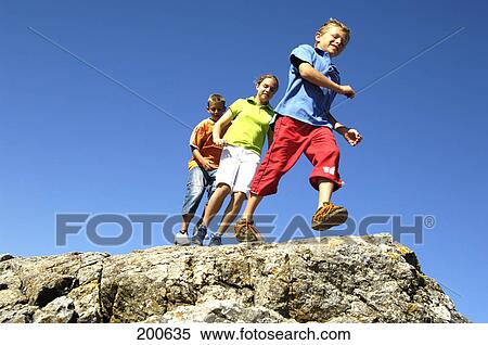 Low angle view of three children walking on cliff View Large Photo Image Stock Photography - Low angle view of three children walking on cliff . Fotosearch