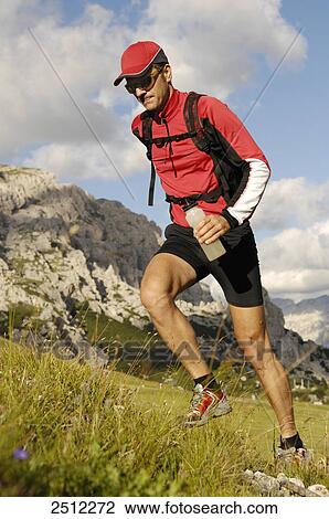 Male athlete in sportswear running up a grassy hill in Trentino, Southern Tyrol, in the background the Dolomites View Large Photo Image Stock Image - Male athlete in sportswear running up a grassy hill in Trentino, Southern Tyrol, in the background the Dolomites . Fotosearch