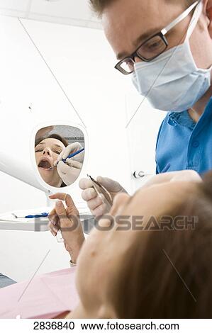 Male dentist examining patient's teeth View Large Photo Image Stock Image - Male dentist examining patient's teeth . Fotosearch