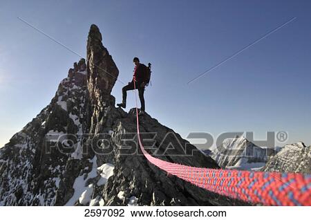 Stock Image - Male mountain hiker standing on mountain peak, Trentino-Alto Adige, Italy . Fotosearch