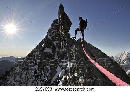 Stock Image - Male mountain hiker standing on mountain peak, Trentino-Alto Adige, Italy . Fotosearch